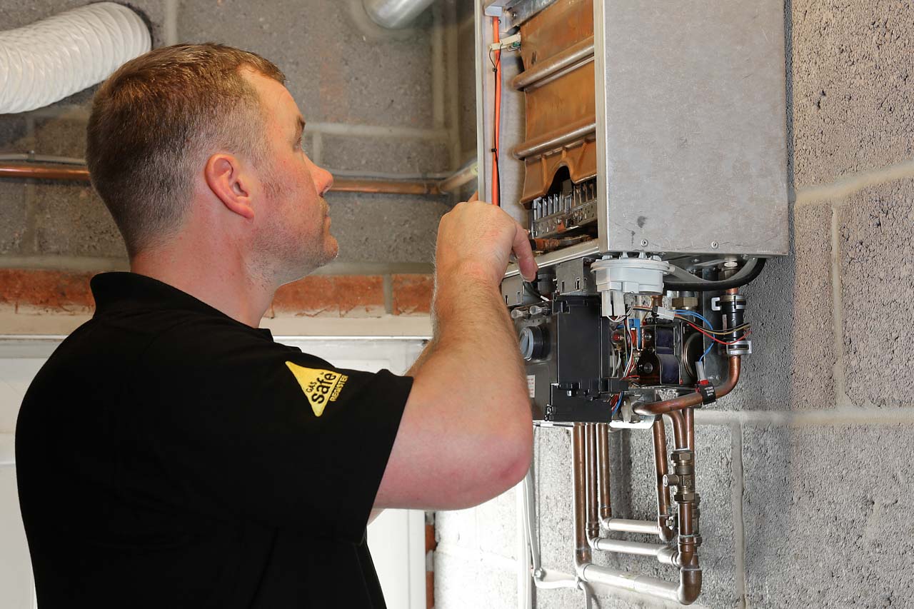 New Gas Boiler Installation showing engineer fitting a new gas boiler